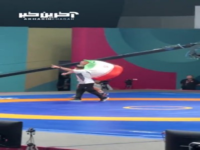 دور افتخار هادی ساروی با پرچم پس از کسب مدال طلای ۹۷ کیلوگرم کشتی فرنگی